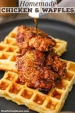 Maple syrup being poured over the top of a plate filled with crispy chicken and waffles.