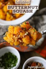 A person using a large serving spoon to hold up a mound of Maple-Glazed Butternut Squash with Pancetta and Herbs.