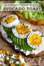 A close-up view of a high-protein avocado toast with a slice of toasted multi grain bread on the bottom, topped with a layer of cottage cheese, sliced avocaod, and slices of a soft-boiled egg and garnished with fresh dill, salt, and pepper.