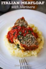 A slice of The Best Juicy Italian Meatloaf with Marinara Glaze resting on a pile of mashed potatoes on a white dinner plate.