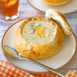 A close-up view of sourdough bread bowl filled with Broccoli Cheddar Soup (Panera Copycat)
