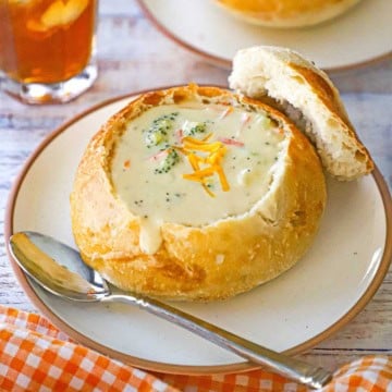 A close-up view of sourdough bread bowl filled with Broccoli Cheddar Soup (Panera Copycat)