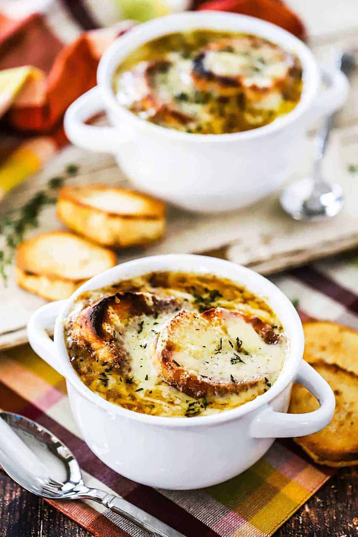 Two soup bowls filled with homemade French onion soup.