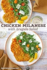 An overhead view of two dinner plates filled with servings of crispy chicken Milanese with arugula salad.