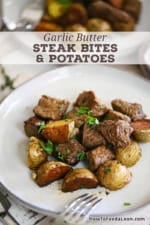A small dinner plate filled with a serving of garlic butter steak bites and potatoes.