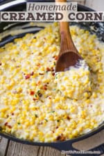 A person using a wooden spoon to raise a serving of homemade creamed corn from a skillet filled with the same.