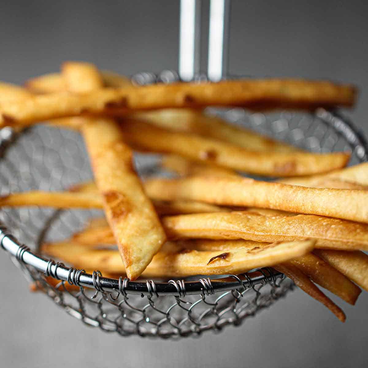 A metal spider raising strips of fried flour tortillas.
