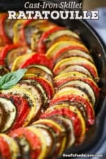 A close-up view of spiral rows of cooked vegetables in a cast-iron skillet ratatouille.