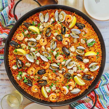 An overhead view of a large paella pan filled with freshly prepared Authentic Spanish Seafood Paella.