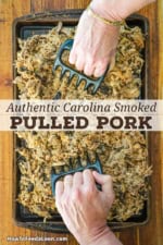 A person using plastic meat claws to shred smoked pork butt in a large steel roasting pan.