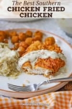 A partially eaten Southern chicken fried chicken on a dinner plate with mashed potatoes next to it.