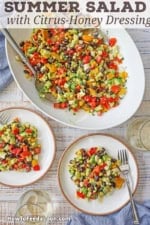 An overhead view of a large platter filled with a Southwestern Summer Salad with Citrus-Honey Vinaigrette with two small plates next to if filled with the same salad.