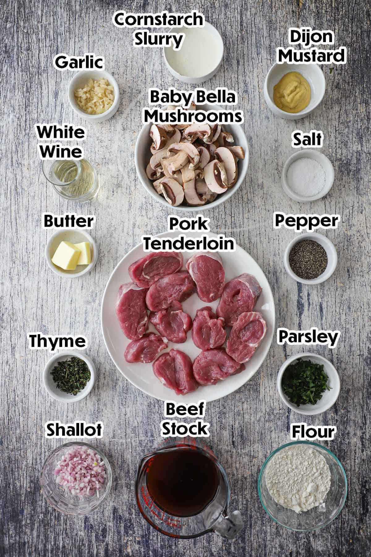 An arrangement of ingredients for Pork Medallions with Mushroom Gravy including pork tenderloin medallions, mushrooms, flour, Dijon, shallots, wine, garlic, cornstarch, herbs, and seasonings.