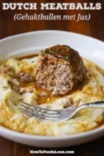 A half eaten Dutch meatball that is topped with a brown gravy and is resting on a partially eaten bed of mashed potatoes in a shallow white bowl.